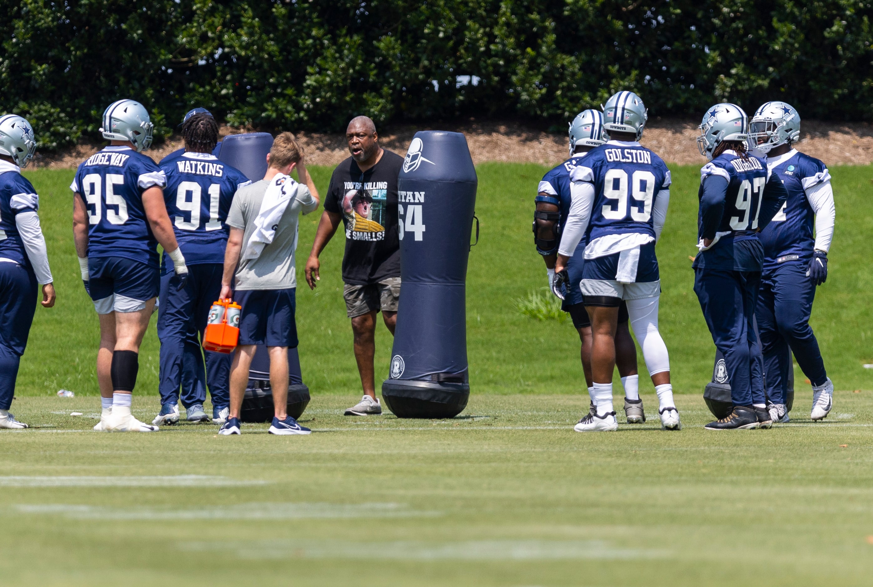 Former Dallas Cowboys Charles Haley, center, coaches the defensive linemen during practice...