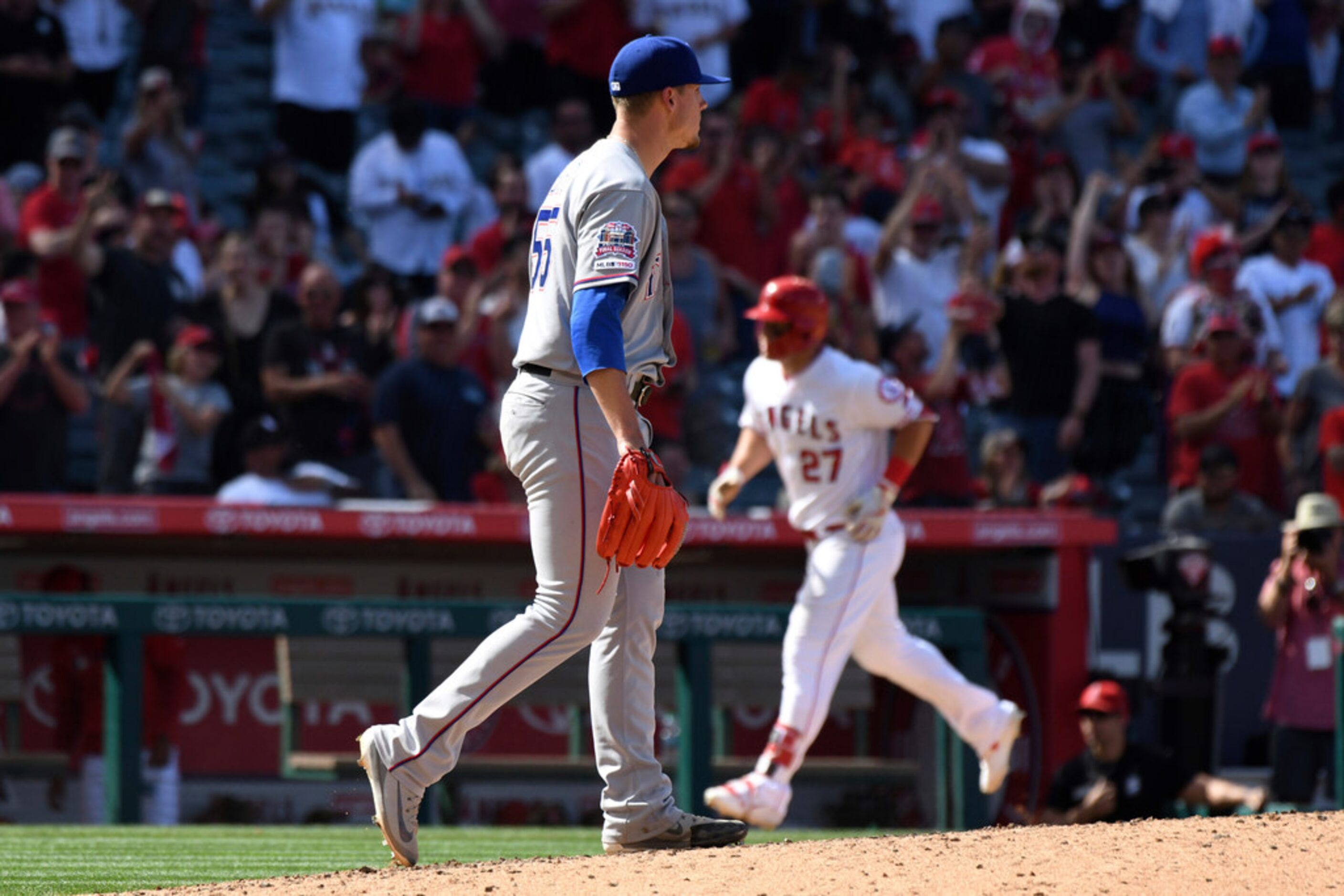 Texas Rangers pitcher Kyle Bird waits as Los Angeles Angels' Mike Trout runs the bases after...