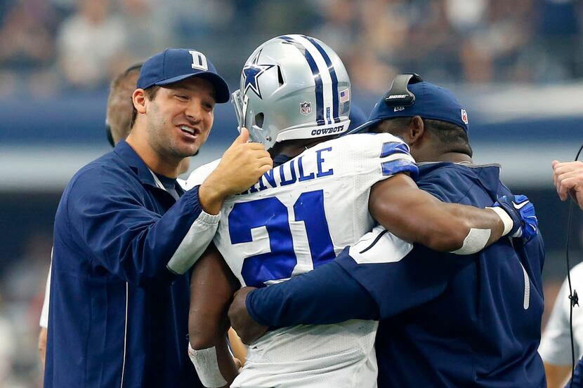 Dallas Cowboys quarterback Tony Romo (left) is excited for running back Joseph Randle (21)...