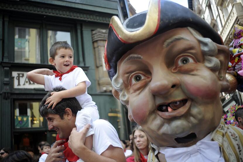 
Cabezudos (Big-Heads) chase parents and children in the crowds during the children’s...