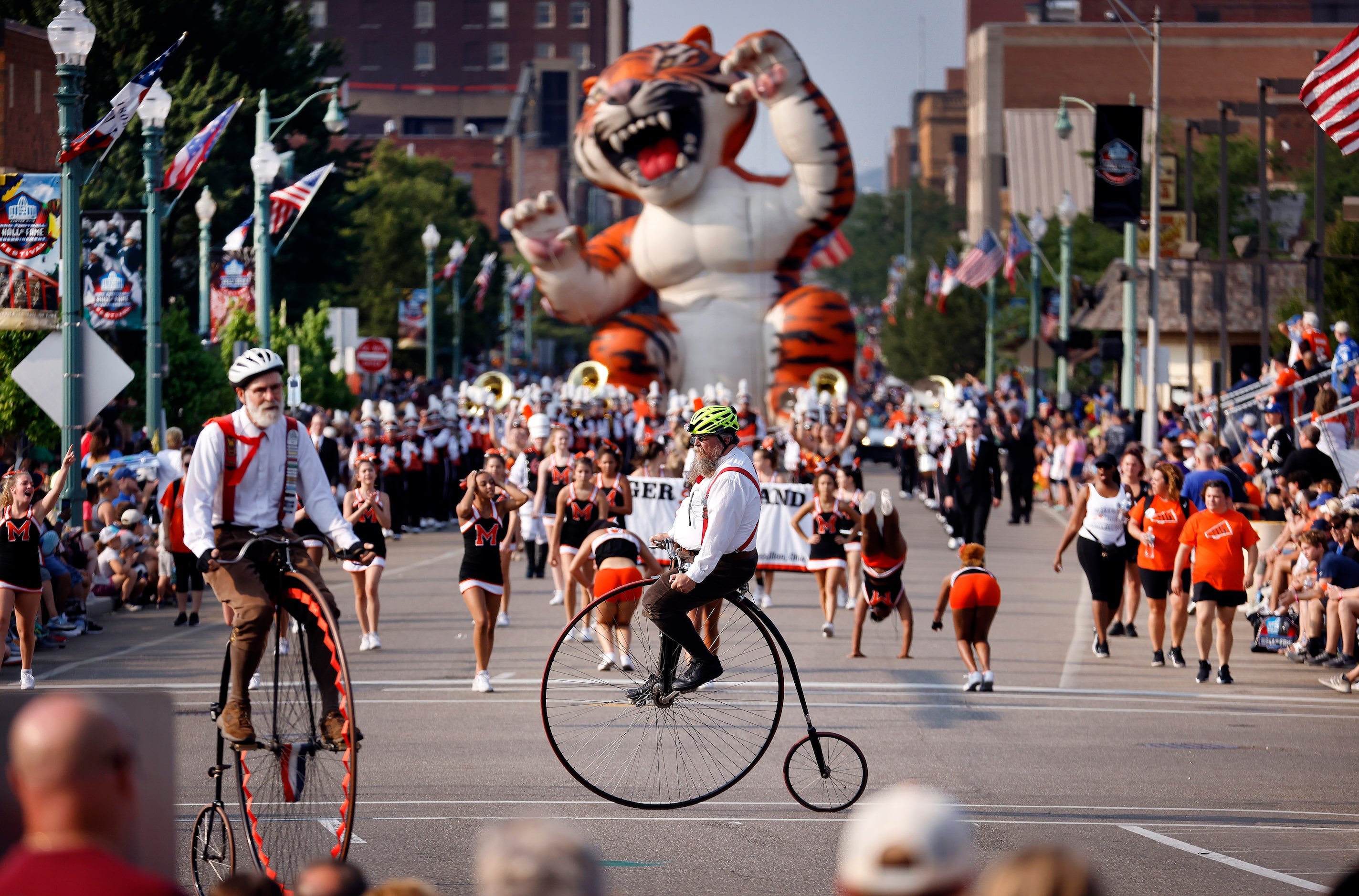 Men on tall bicycles entertain the crowd along Cleveland Ave during the Canton Repository...