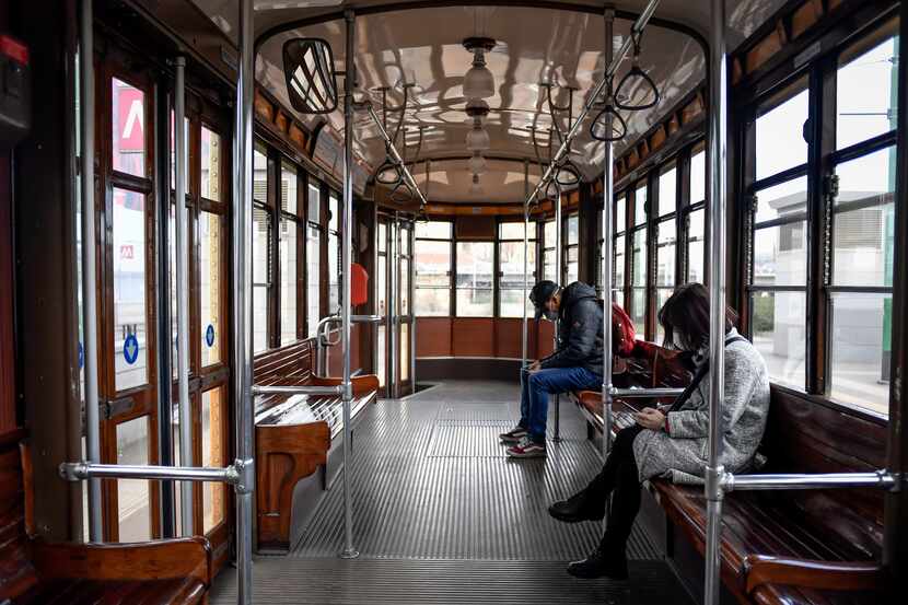 People wear sanitary masks as they ride an empty tram in downtown Milan, Italy, Wednesday,...