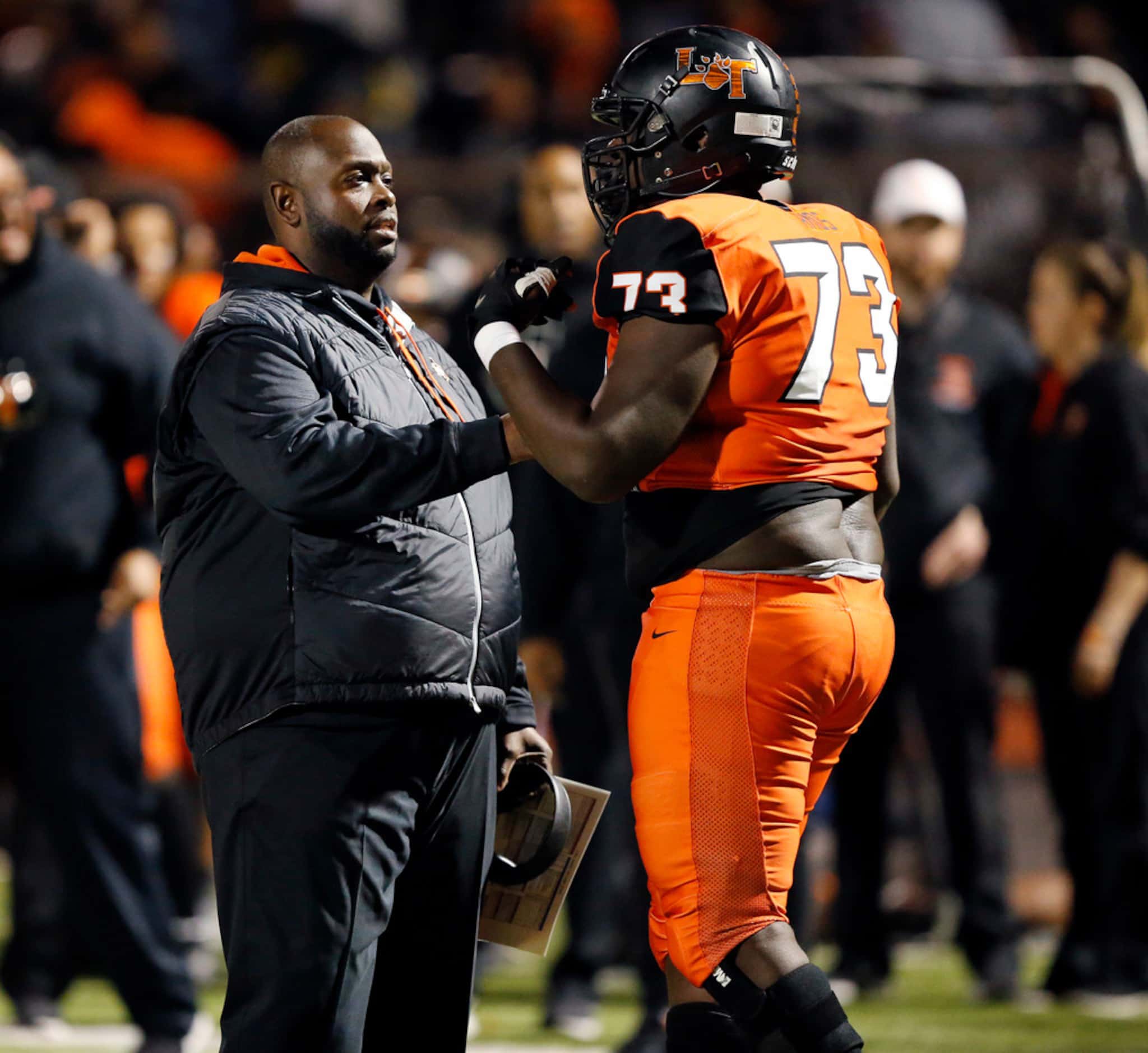 Lancaster head coach Chris Gilbert visits with his lineman Joseph Amos after a personal foul...