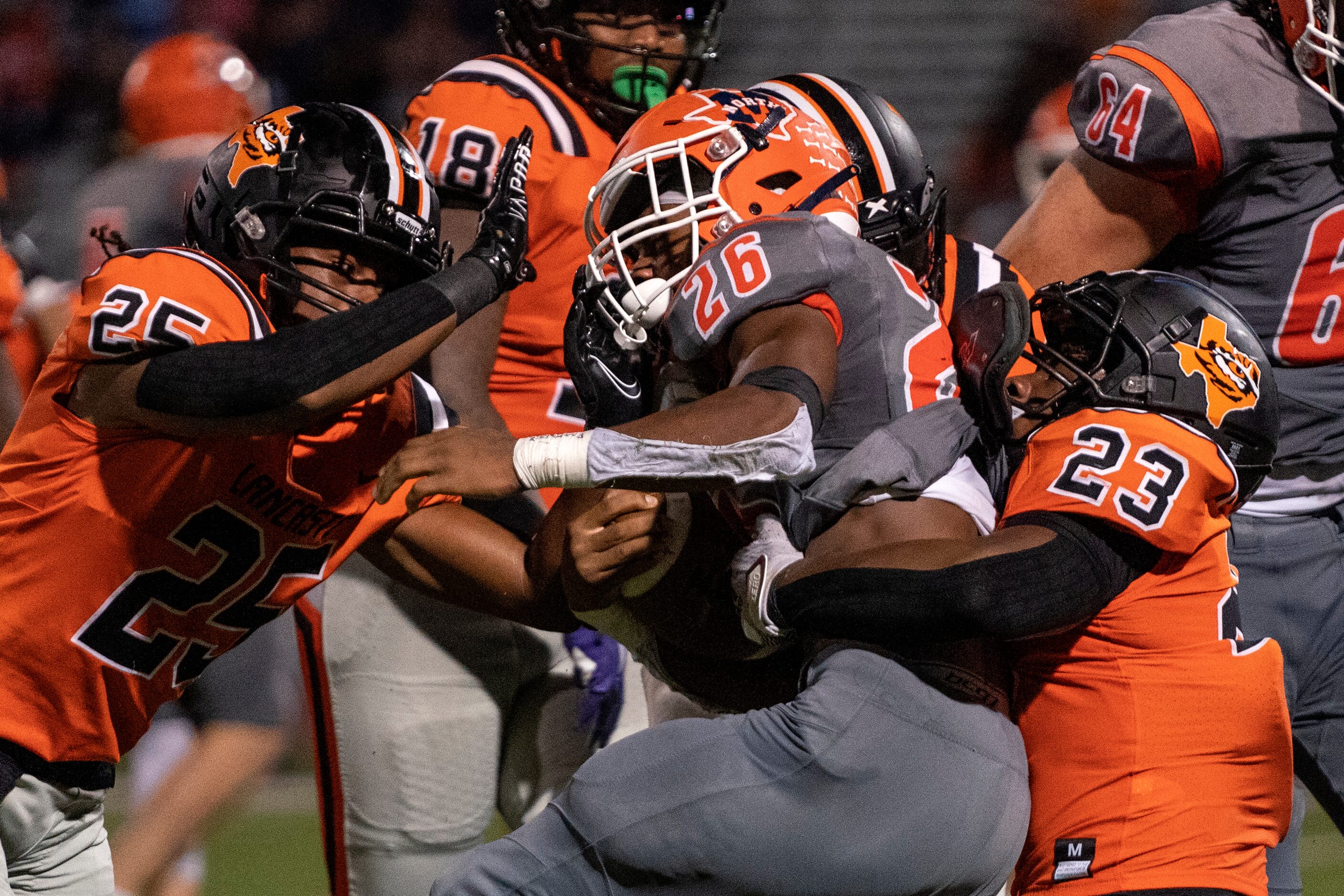 McKinney North sophomore running back Emmanuel Crosby (26) is corralled by Lancaster senior...