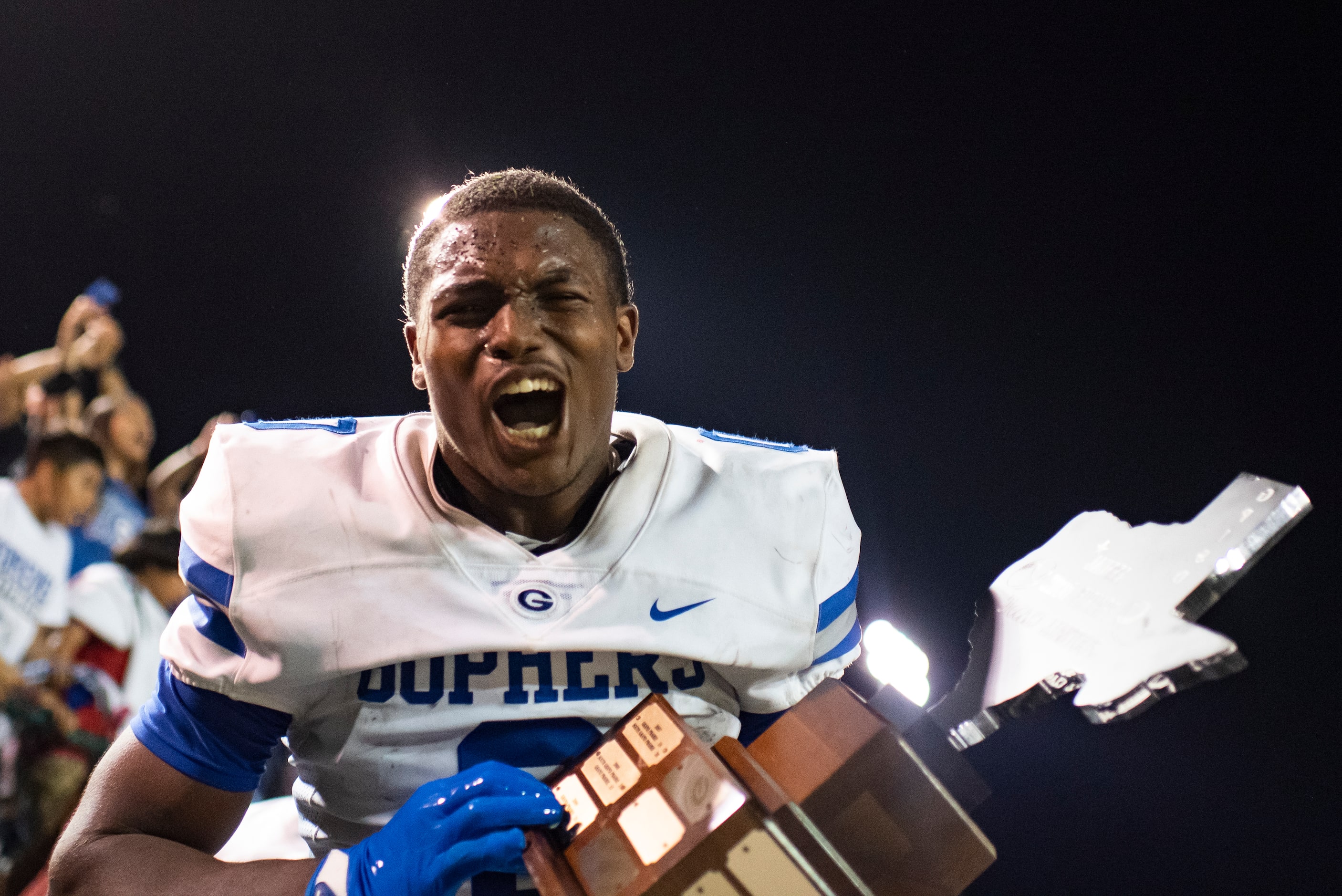 Grand Prairie senior Savion Red (0) exclaims while holding the trophy after the conclusion...