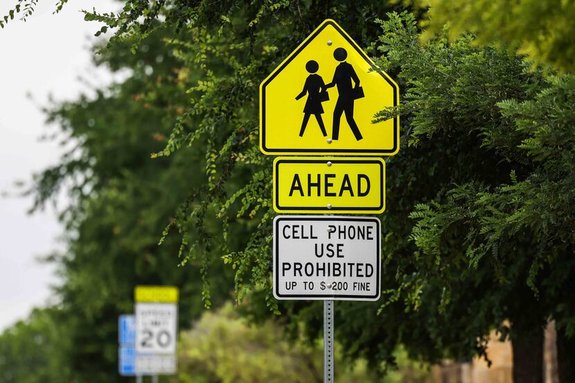 A warning notice not to use cellular devices around school grounds is displayed near...