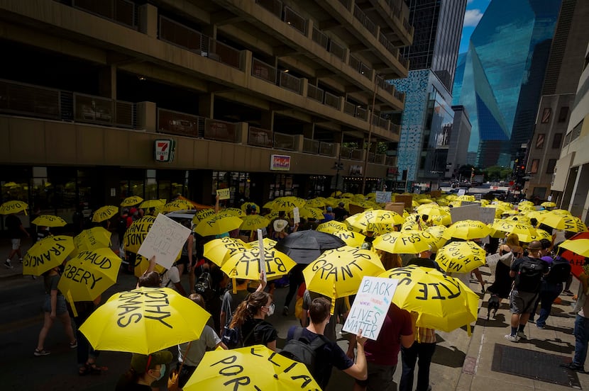 Demonstrators, many carrying umbrellas bearing the names of people who have been killed by...