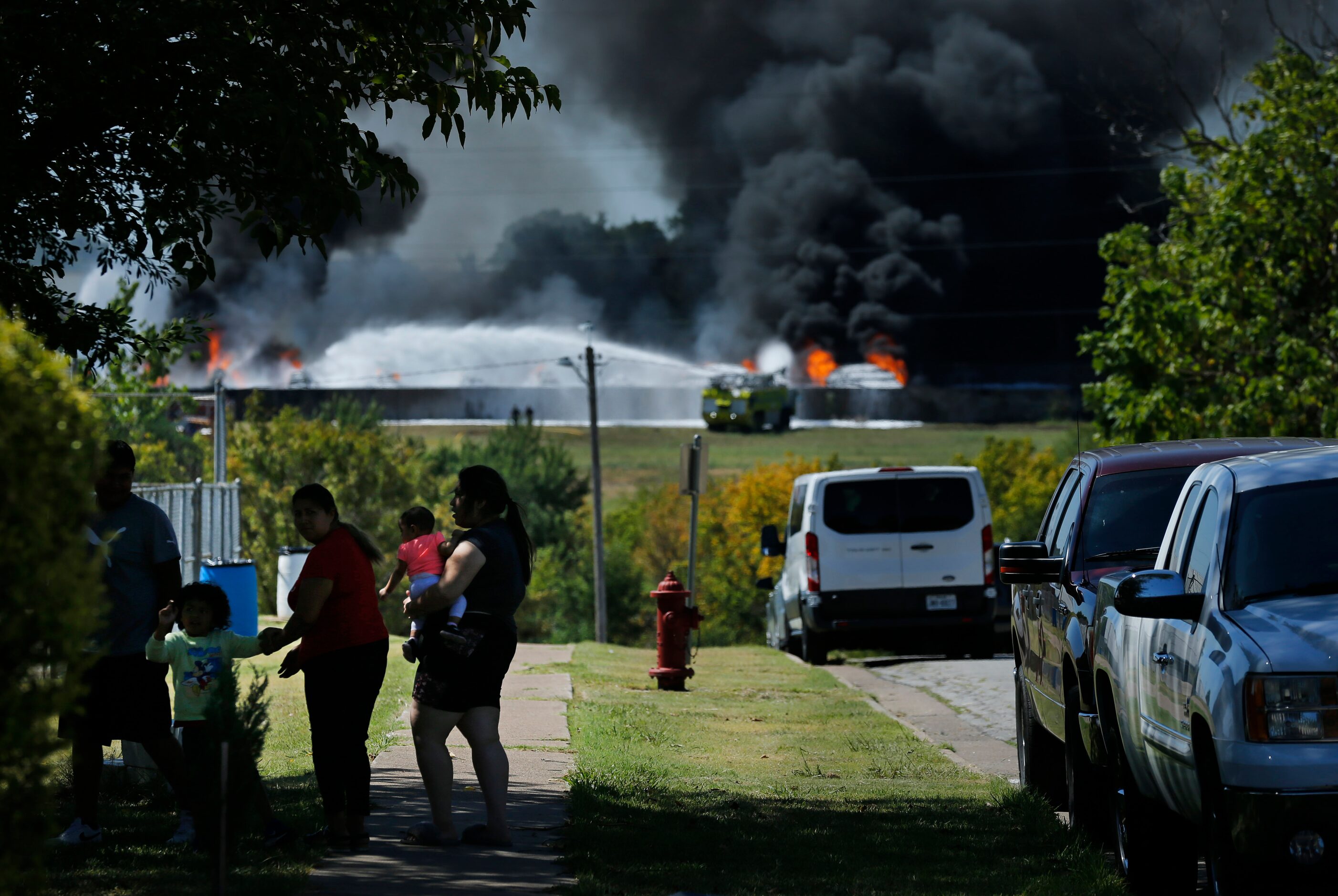 Black smoke from burning plastic billows at Poly-America as nearby neighbors came out to...