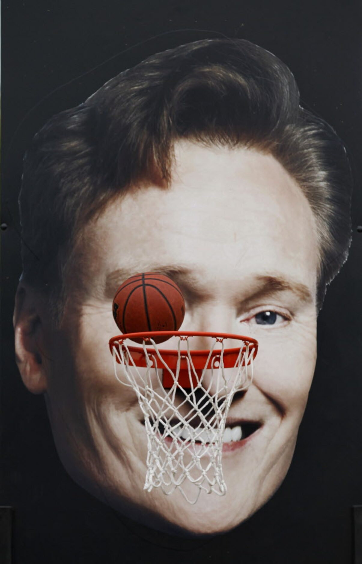 A fan tries to shoot a basket into Conan O'Brien's face at the Cone Zone at the March...