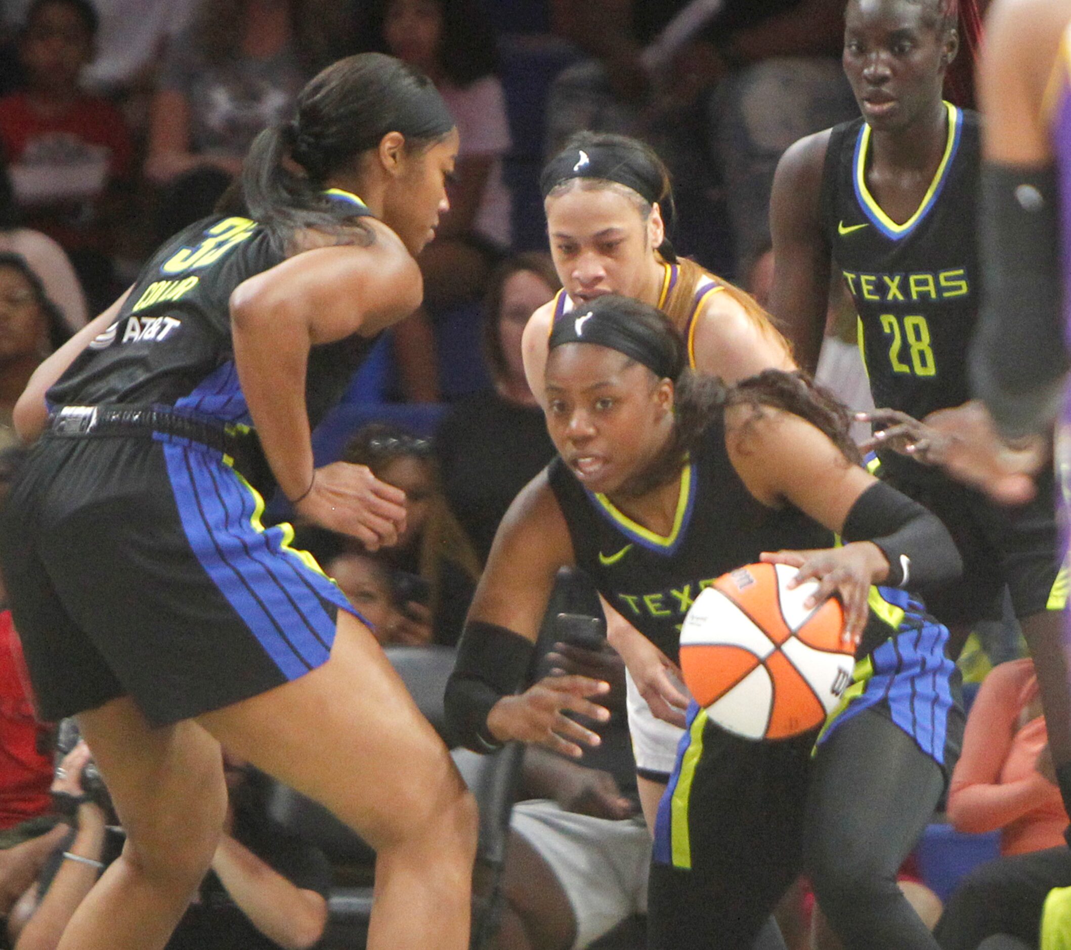 Dallas Wings guard Arike Ogunbowale (24) emerges from a group of players with control of the...