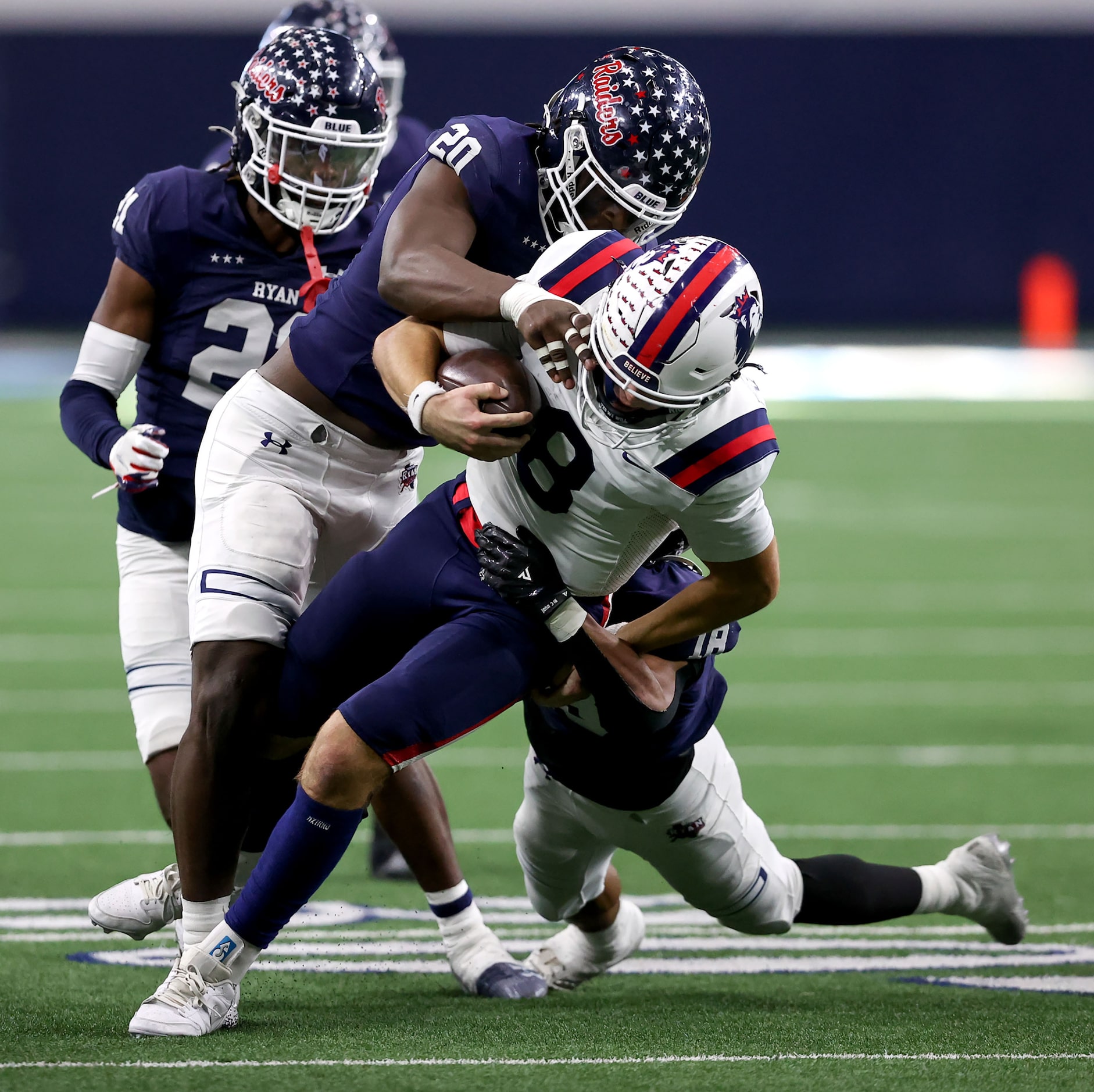 Richland quarterback Drew Kates (8) gets brought down by Denton Ryan defensive lineman...