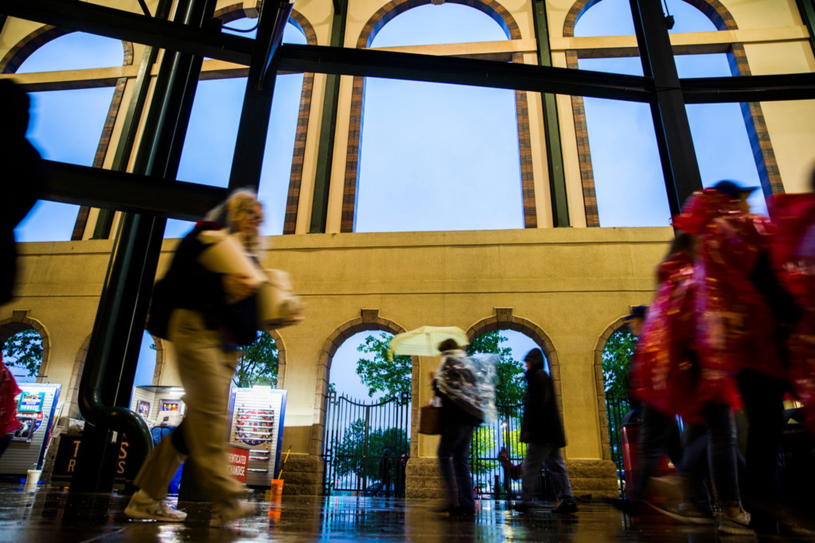 Fans leave the stadium after a rain delay at an MLB game between the Texas Rangers and the...