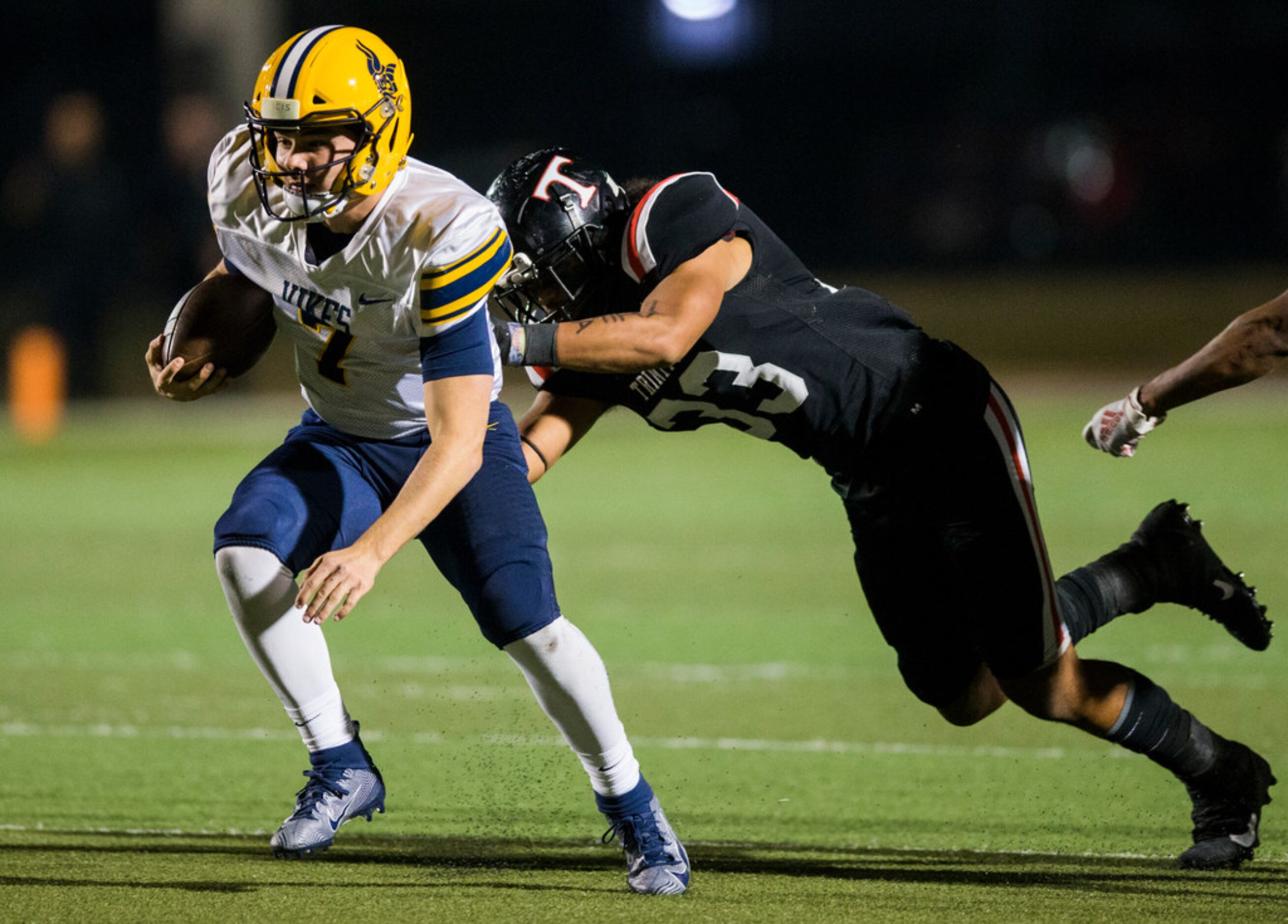 Arlington Lamar quarterback Jack Dawson (7) is tackled by Euless Trinity defensive back...