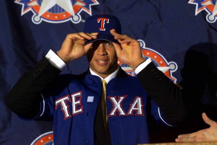 Alex Rodriguez (cq) tries on a  Texas Ranger's ballcap before talking at his first media...