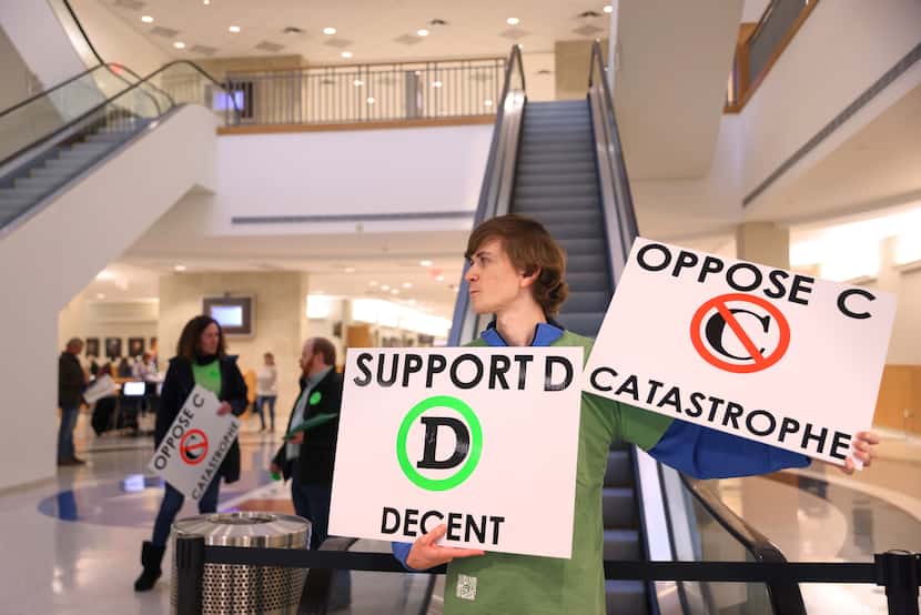 JD Eubank holds signs opposing a segment of the future U.S. 380 bypass in the lobby of the...