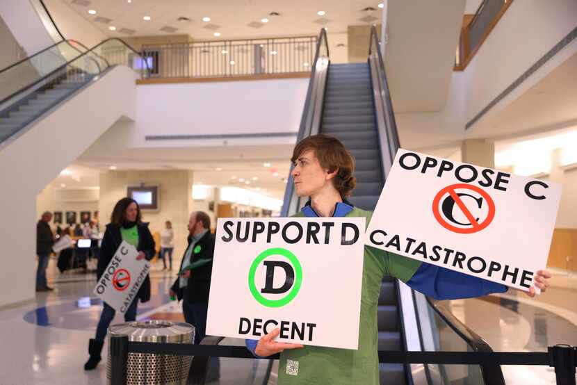J.D. Eubank holds signs opposing a segment of the future U.S. 380 bypass in the lobby of the...