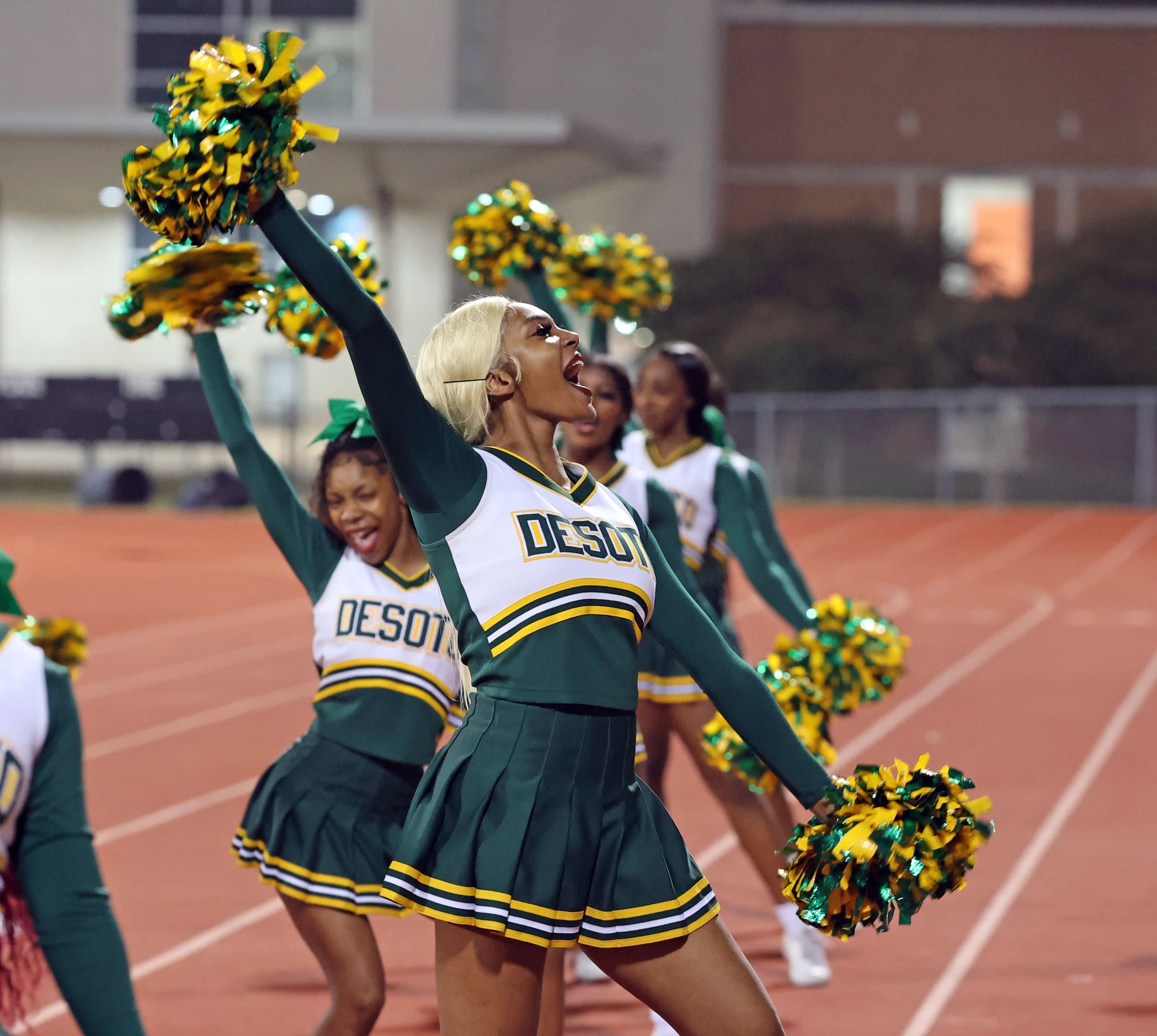 The DeSoto high cheerleaders yell during the first half of a high school football game...