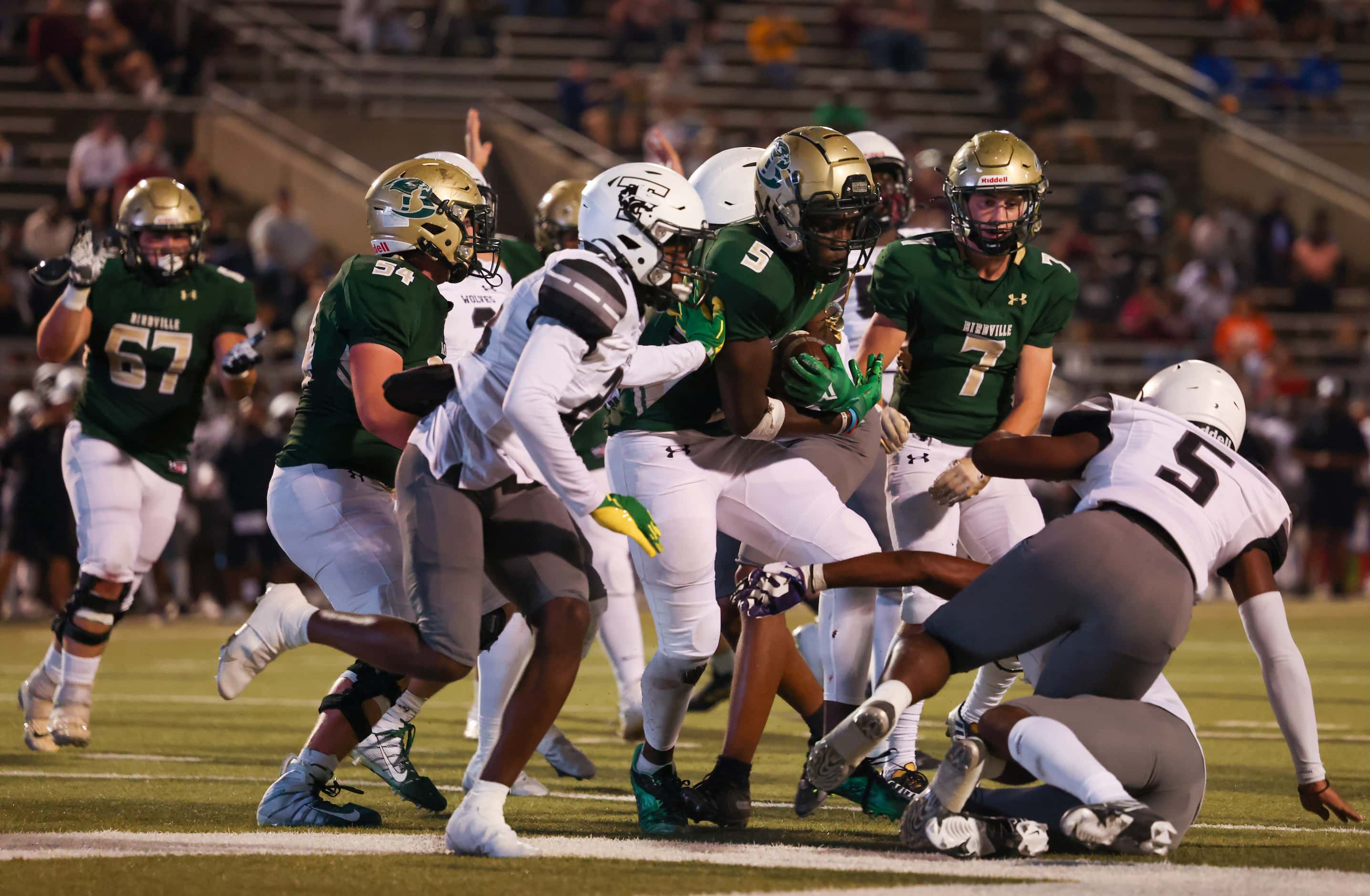 Birdville wide receiver Sekou Konate (5) pushes past Mansfield Timberview defenders for a...