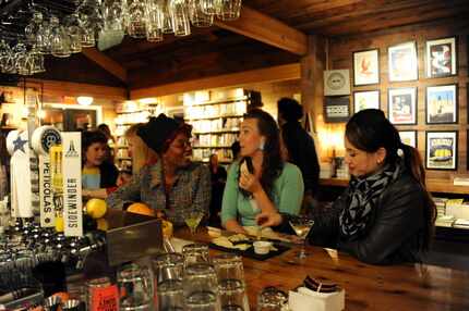 Chesley Antoinette, Cat Cole, and Pilar Zornosa sit at the bar, sip cocktails and eat cheese...