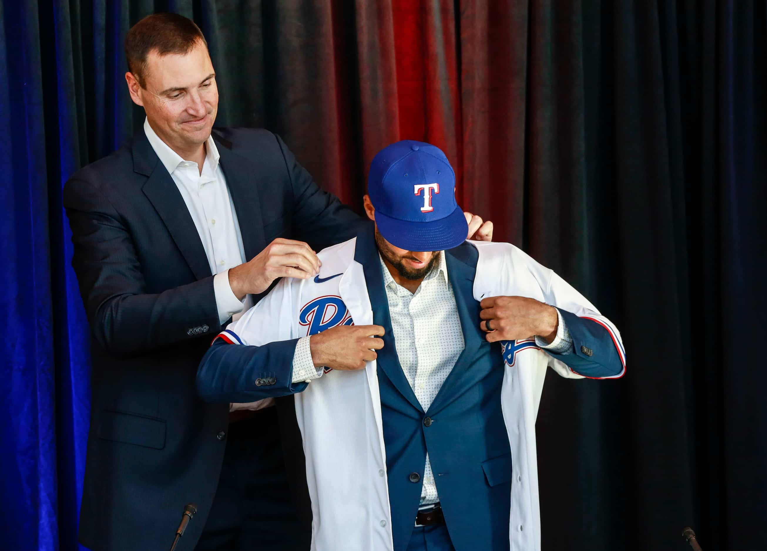 Marcus Semien puts on his jersey at a news conference at Globe Life Park in Arlington on...
