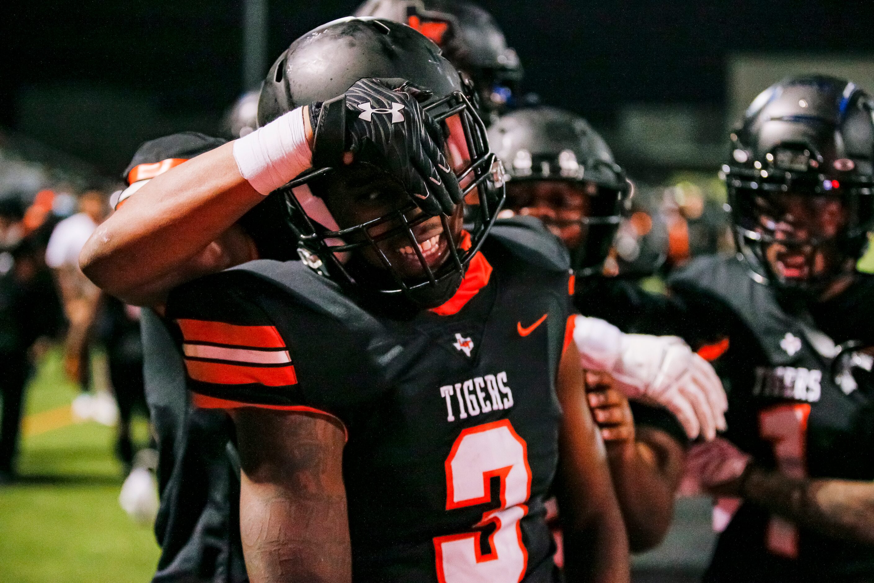 Lancaster junior quarterback Glenn Rice Jr. (3) is congratulated by teammates after scoring...