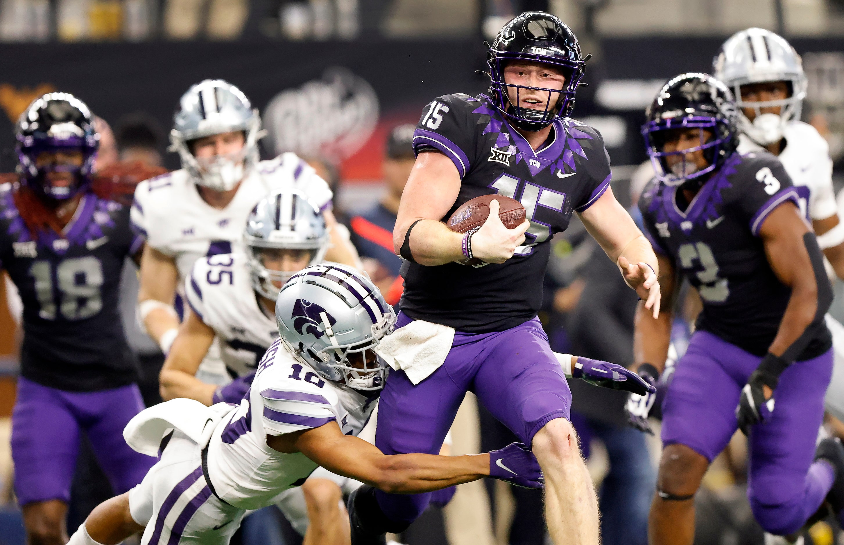 TCU Horned Frogs quarterback Max Duggan (15) caries the ball as he’s tackled by Kansas State...