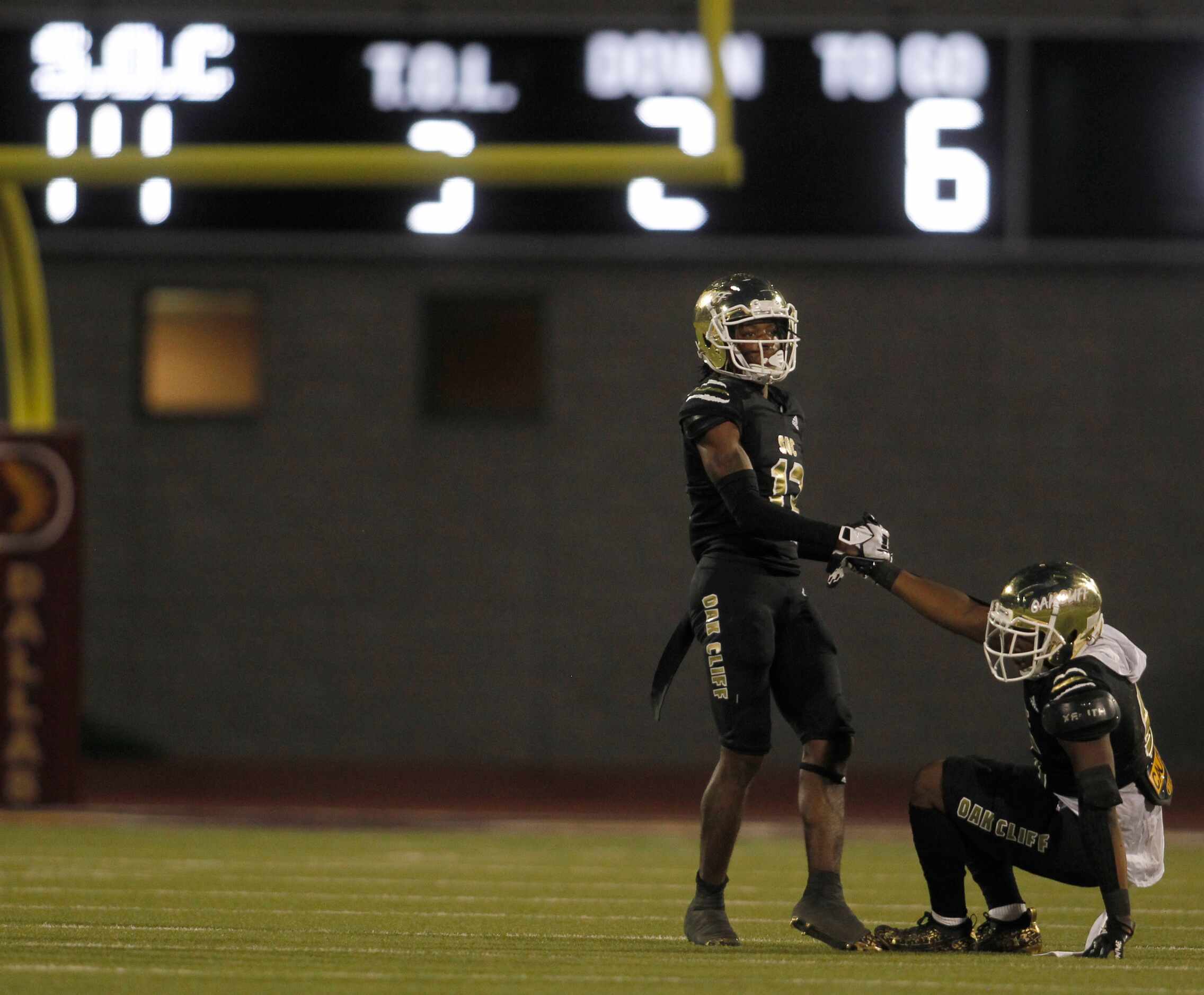 South Oak Cliff defensive back Taylor Starling (13), left, helps teammate Adul Muhammad (6)...