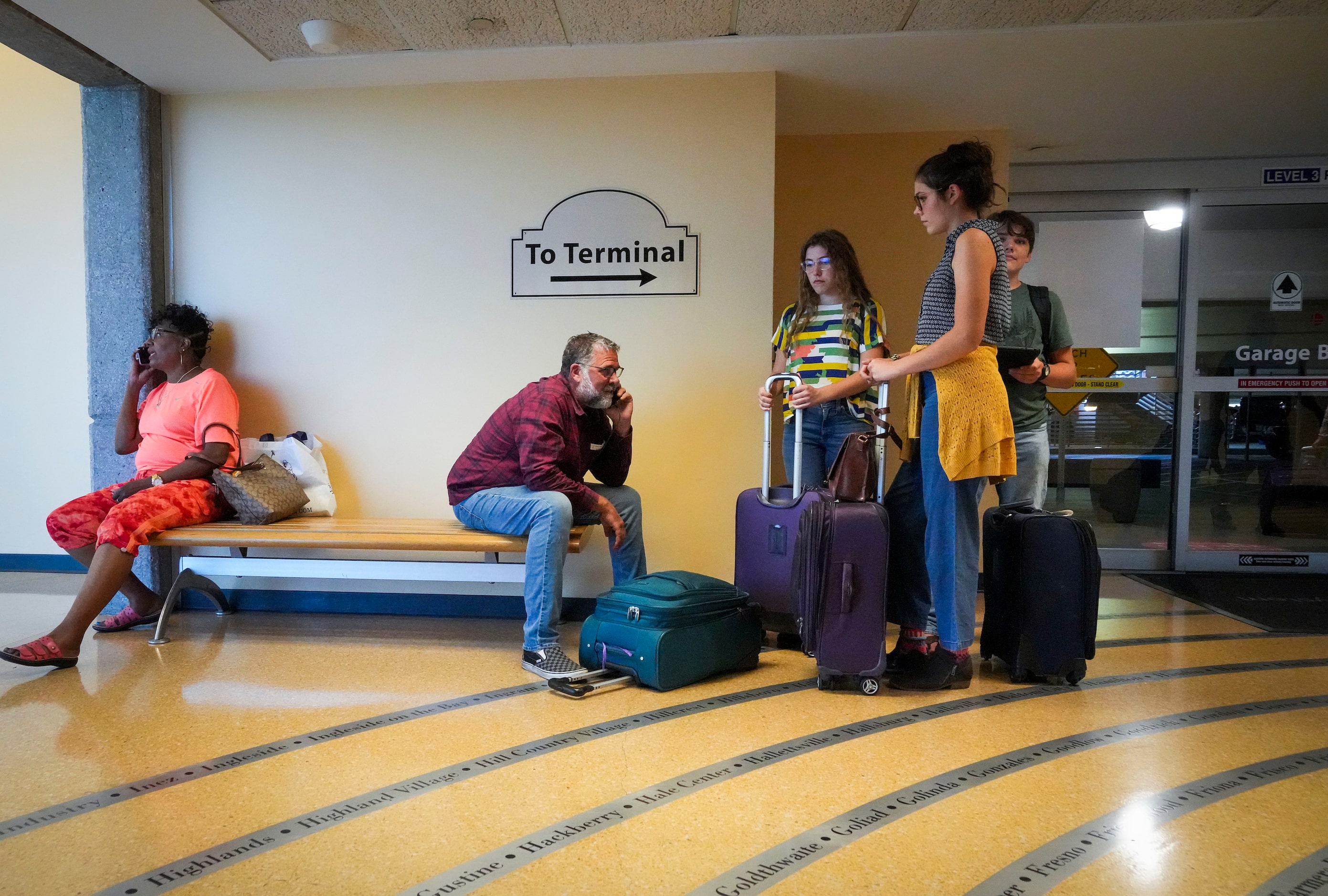 Passengers wait to reenter Dallas Love Field Airport on Monday, July 25, 2022.  A ground...