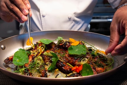 Chef Junior Borges puts the final touches on grilled octopus at Meridian restaurant in 2021.