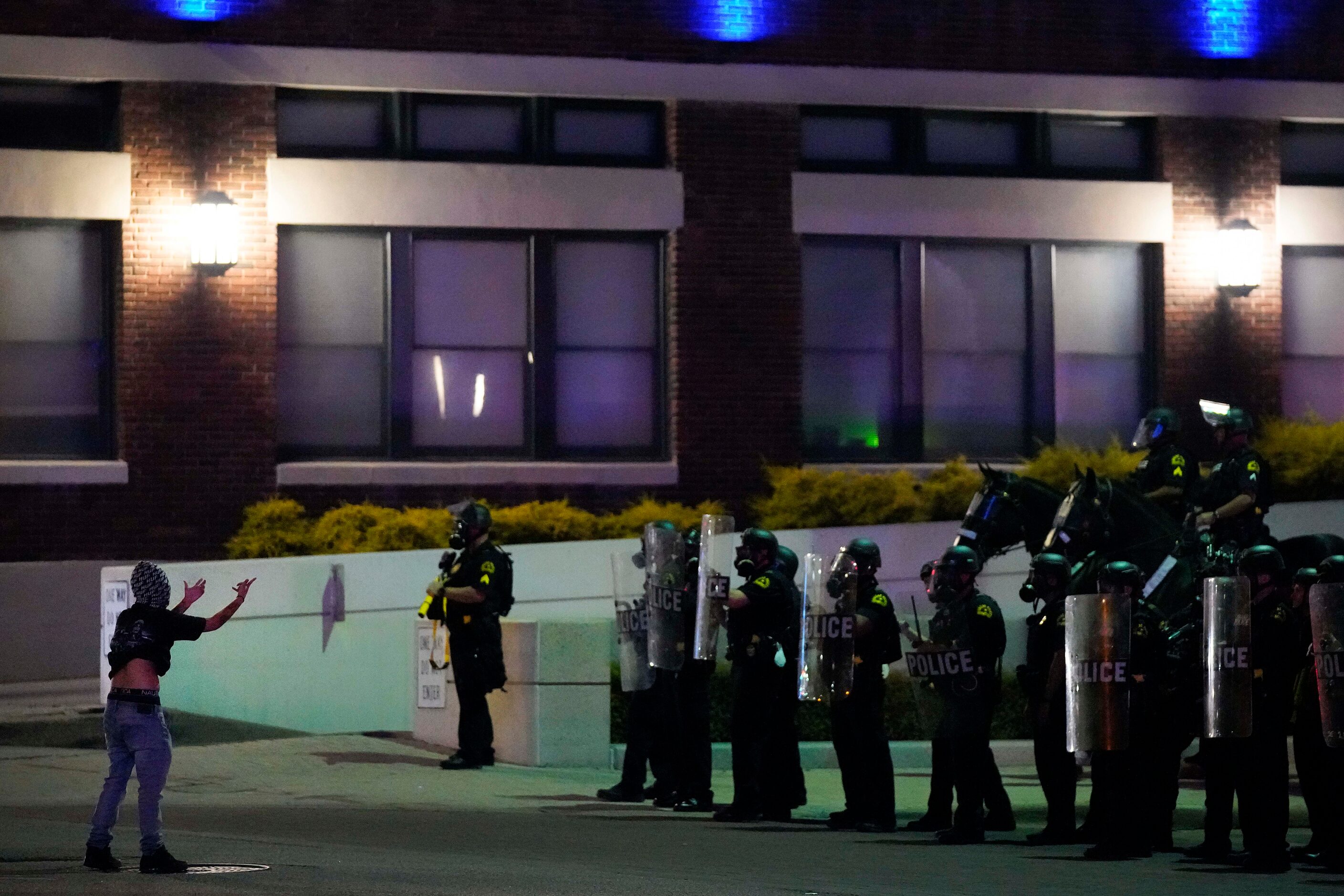 A protesters faces off against a line of Dallas police at the corner of of Griffin and Young...