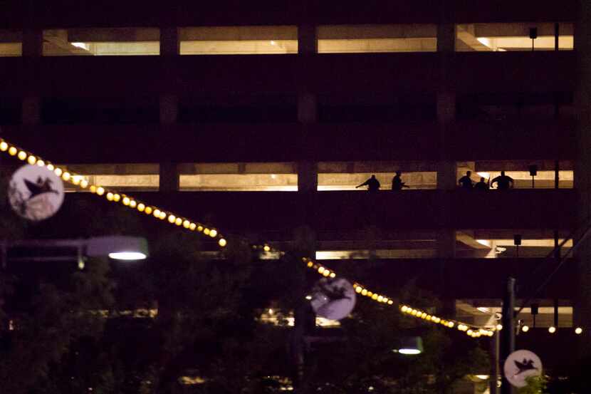 Silhouettes of law enforcement officers are seen in a parking garage at Lamar and Main...