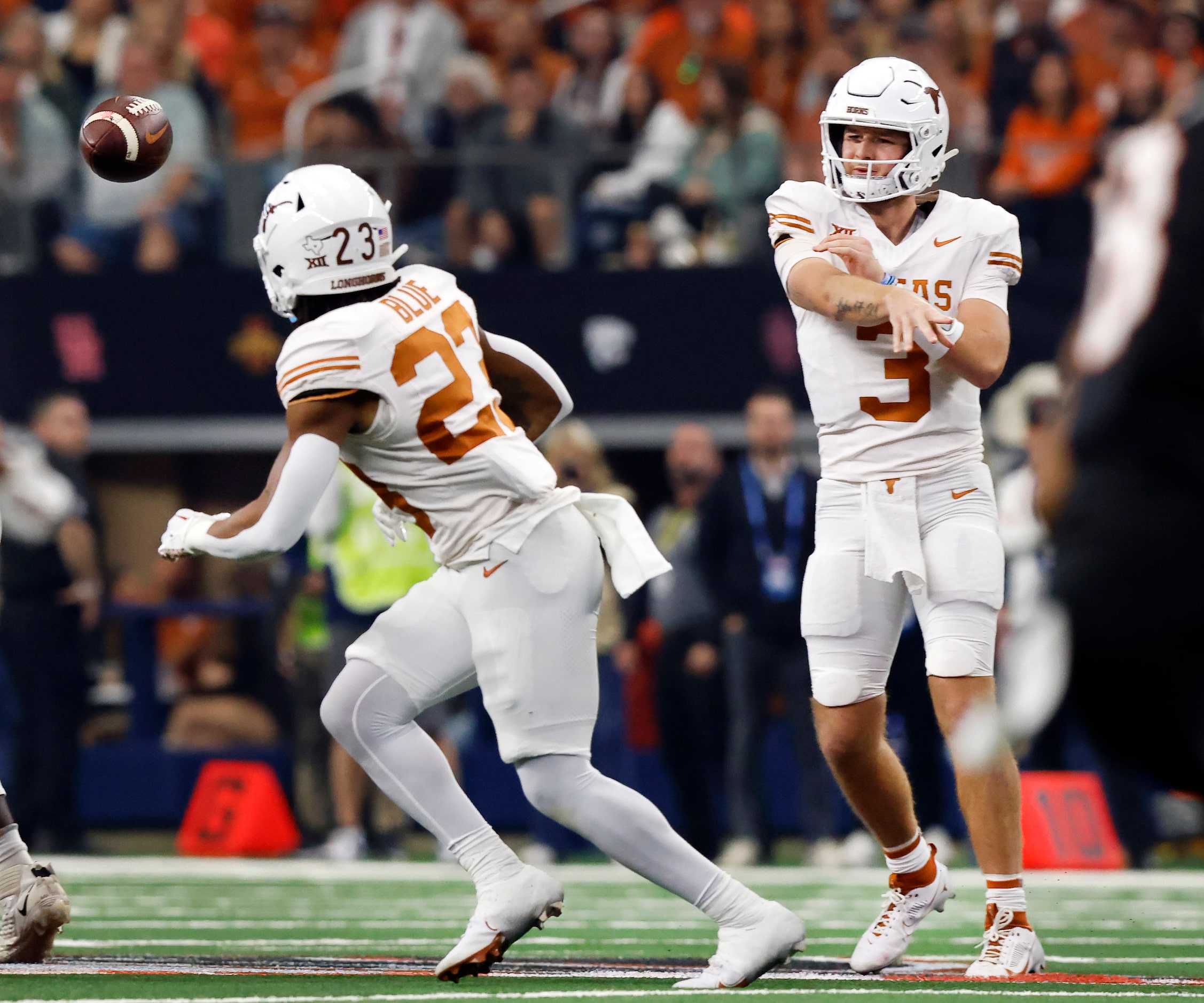 Texas Longhorns quarterback Quinn Ewers (3) throws a pass to running back Jaydon Blue (23)...