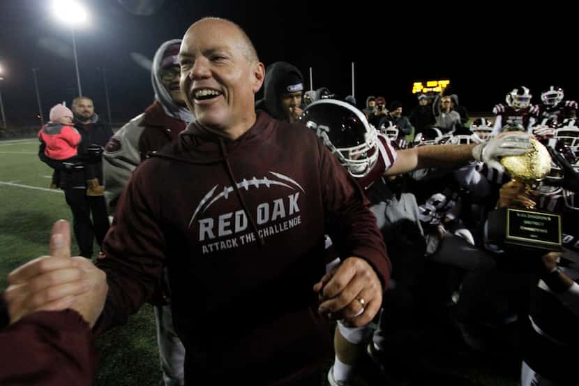 Red Oak coach Chris Ross receives congratulations as his players celebrate winning the...