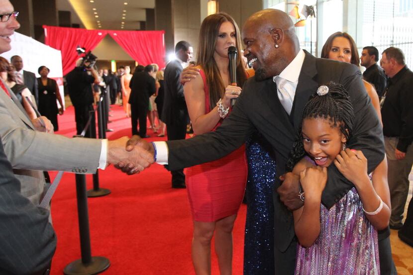 Former Dallas Cowboys running back Emmitt Smith playfully holds his daughter Skylar Smith as...