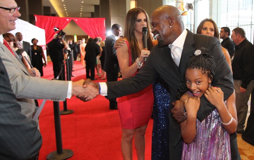 Former Dallas Cowboys running back Emmitt Smith playfully holds his daughter Skylar Smith as...