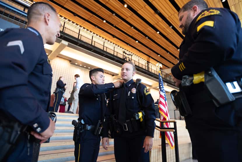 Senior Cpl. Binh Vu( left) places a pin on the collar of newly graduated police Officer...
