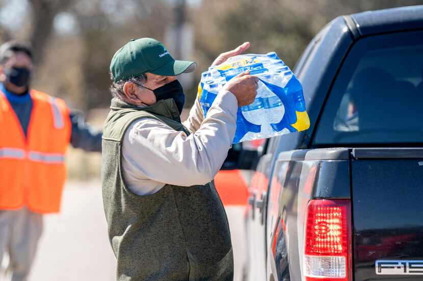 Inocencio Martinez loads a case of bottled water in a pickup truck, Monday, February 22,...