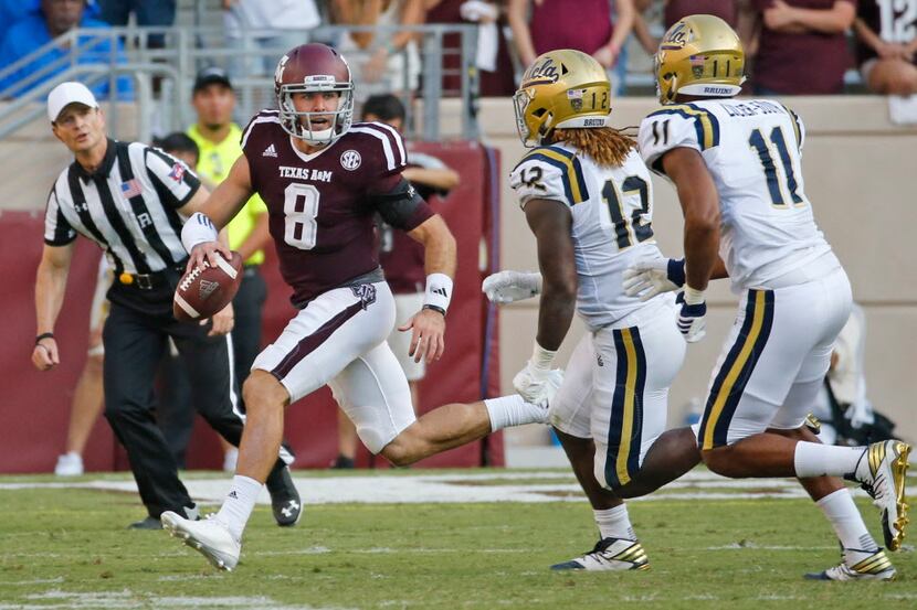 Texas A&M quarterback Trevor Knight (8) scrambles as he looks for a receiver in the fourth...