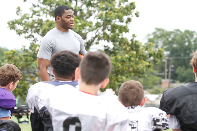 Dallas Cowboys wide receiver Amari Cooper talks to young football players about the...