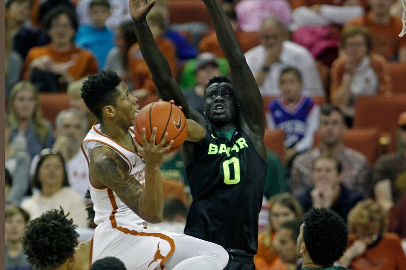 Texas guard Kerwin Roach, left, drives to shoot against Baylor forward Jo Lual-Acuil, Jr.,...