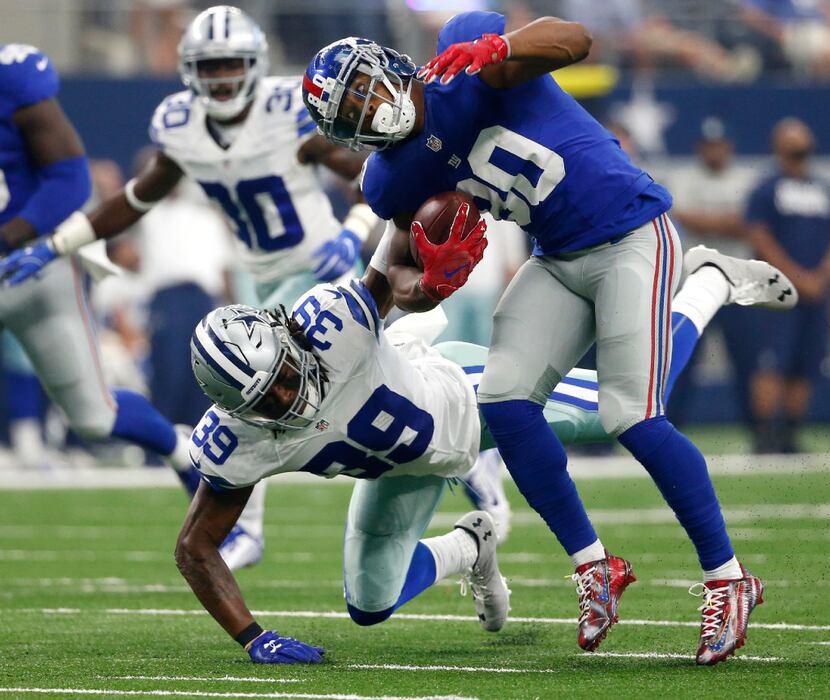 The Cowboys' Brandon Carr brought down Giants receiver Victor Cruz (80) after Cruz hauled in...