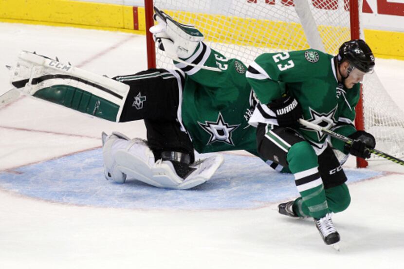 Dallas' Tom Wandell (23) is knocked down by Columbus' Ryan Johansen (19) in the third period...