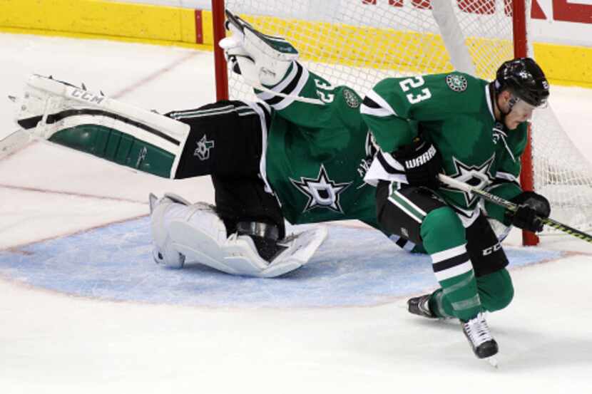 Dallas' Tom Wandell (23) is knocked down by Columbus' Ryan Johansen (19) in the third period...