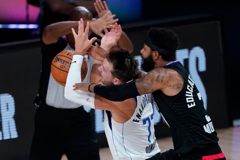 In this Aug. 30, 2020, file photo, Dallas Mavericks' Luka Doncic (77) is fouled by Los...