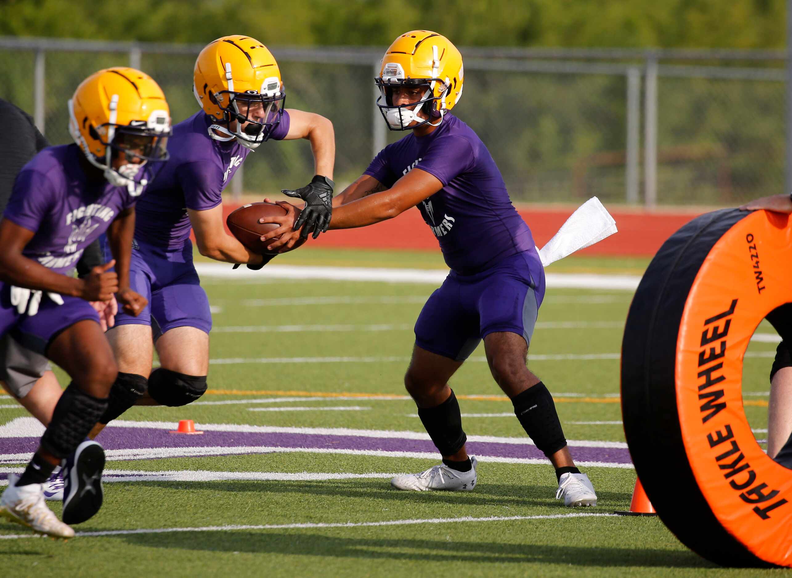 Farmersville's quarterback EJ Chairez fakes a handoff to Braden Lair during the first day of...