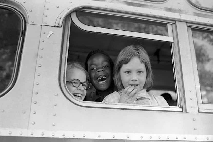 Children smile from window of a school bus in Springfield, Mass., as court-ordered busing...