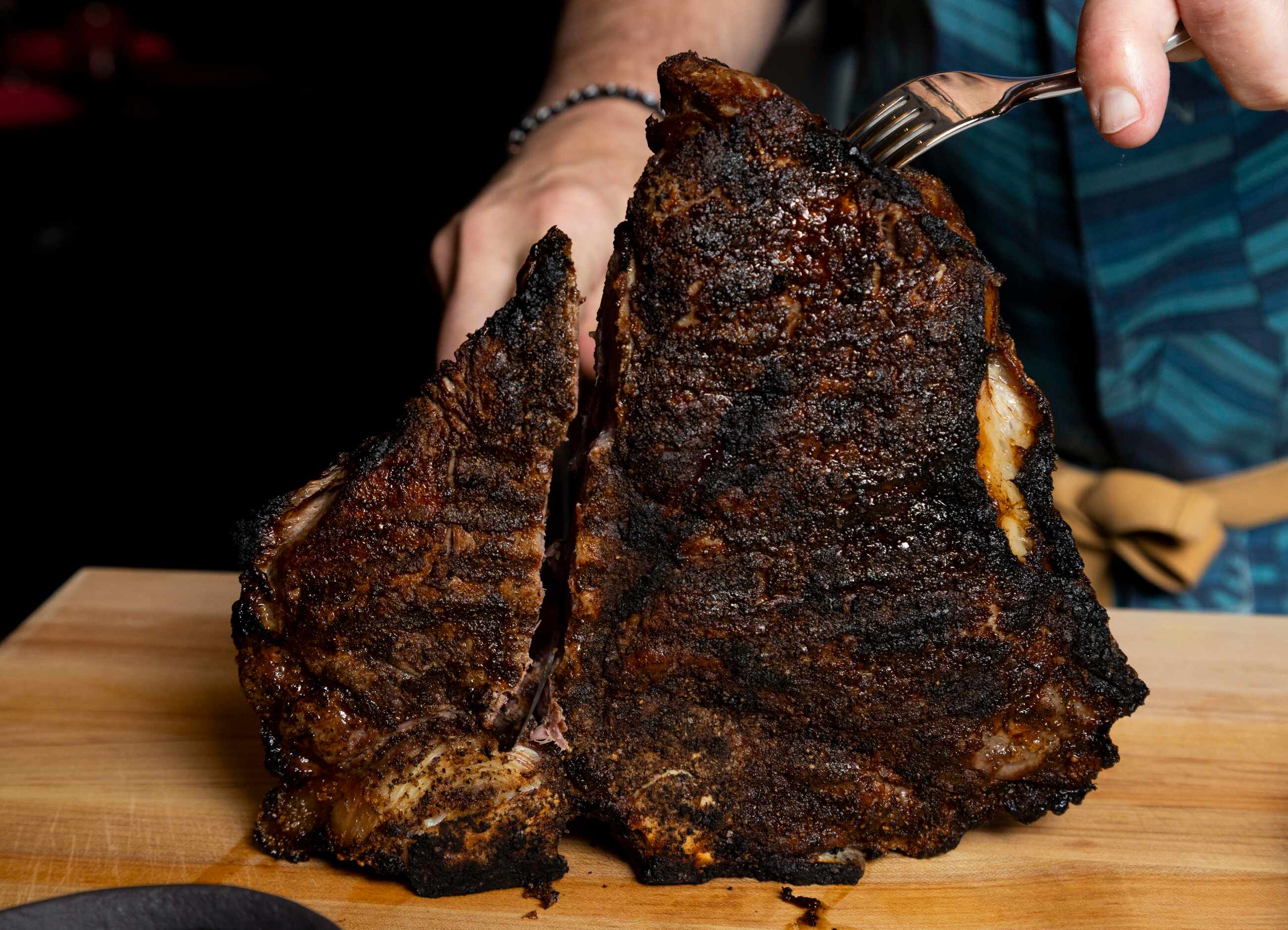 Chef John Tesar carves into a Bistecca A La Las Colinas, a 48 oz 44 Farms dry-aged...