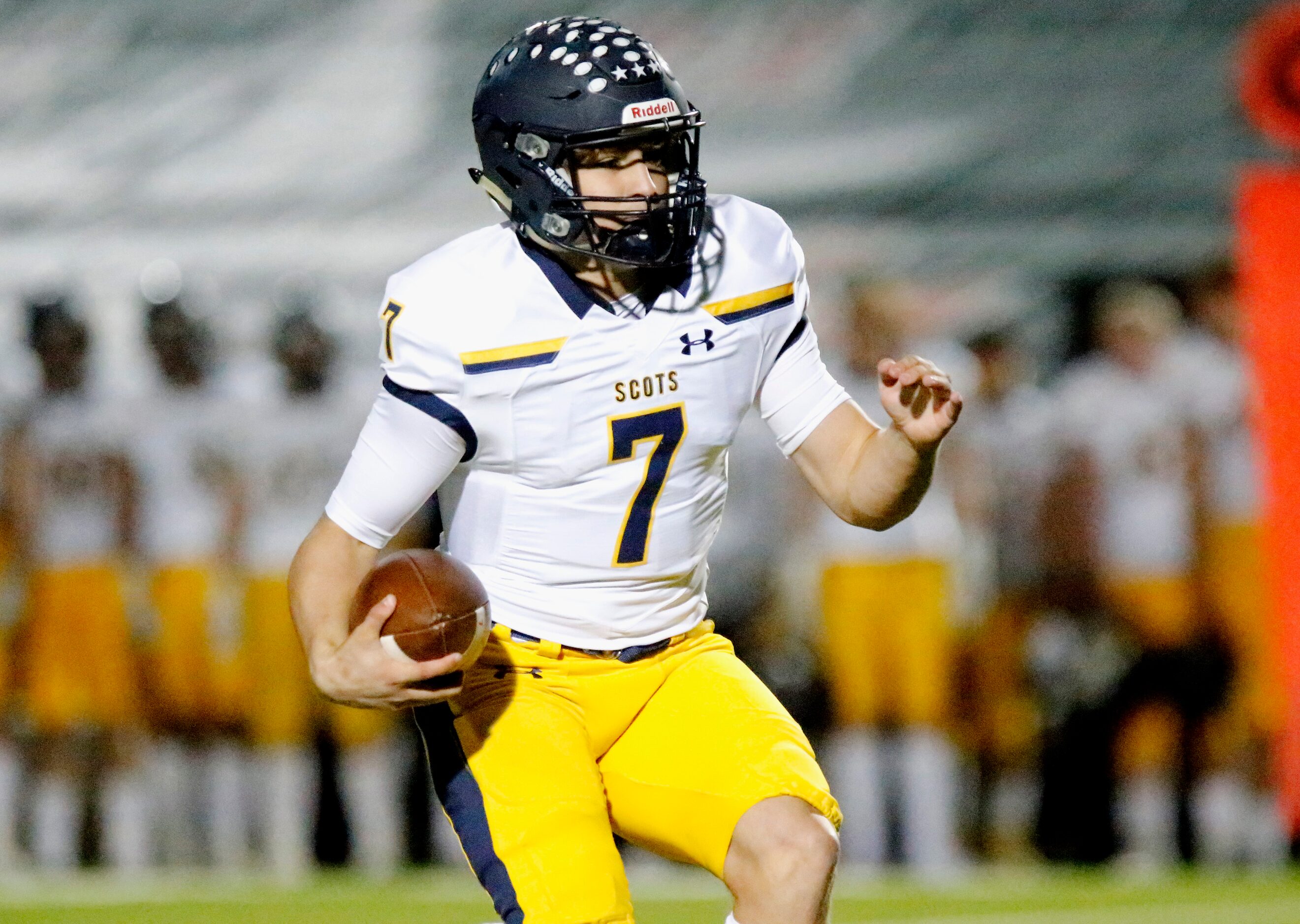 Highland Park High School quarterback Brennan Storer (7) runs for a first down during the...