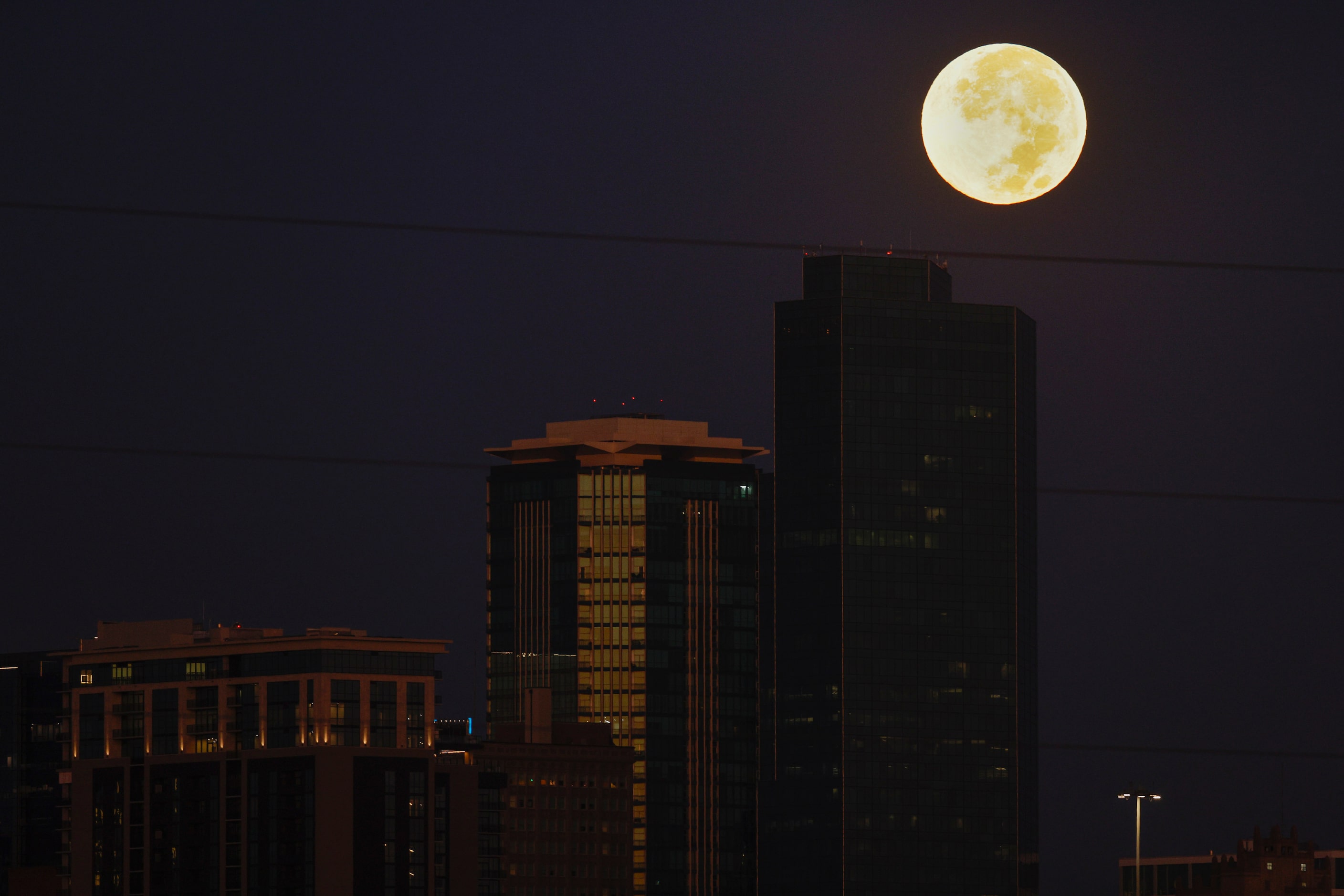 A hunter’s moon sets behind downtown, Thursday, Oct. 17, 2024, in Fort Worth. A hunter’s...