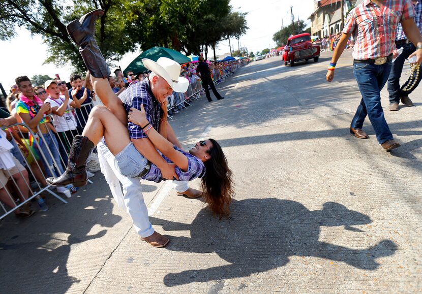 Alex Flores, of Roundup Saloon Dancers, dips country western dance partner Ray Govender of...